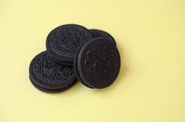 Sarı arka planda birçok Oreo sandviç kremalı bisküvi.