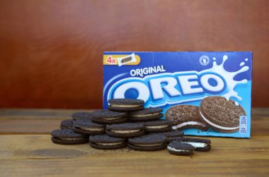 Bir sürü Oreo sandviç kremalı bisküvi ve ahşap arka planda paketler.