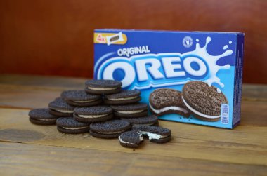 Bir sürü Oreo sandviç kremalı bisküvi ve ahşap arka planda paketler.