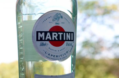 Bir şişe Vermouth Martini Rossi. Yeşil ağaçların arkasındaki logoyu kapat.