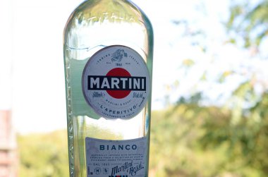 Bir şişe Vermouth Martini Rossi. Yeşil ağaçların arkasındaki logoyu kapat.