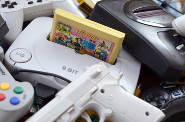 Eski 8-bit video oyun konsolları ve joystickler ve kartuşlar gibi birçok oyun aksesuarı yığını