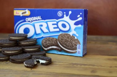 Bir sürü Oreo sandviç kremalı bisküvi ve ahşap arka planda paketler.