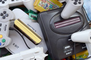 Eski 8-bit video oyun konsolları ve joystickler ve kartuşlar gibi birçok oyun aksesuarı yığını