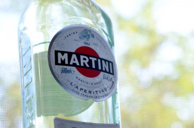 Bir şişe Vermouth Martini Rossi. Yeşil ağaçların arkasındaki logoyu kapat.