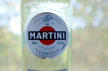 Bir şişe Vermouth Martini Rossi. Yeşil ağaçların arkasındaki logoyu kapat.