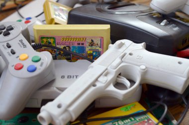 Eski 8-bit video oyun konsolları ve joystickler ve kartuşlar gibi birçok oyun aksesuarı yığını