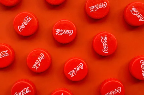 Banyak topi merah dengan logo coca cola pada latar belakang merah — Stok Foto