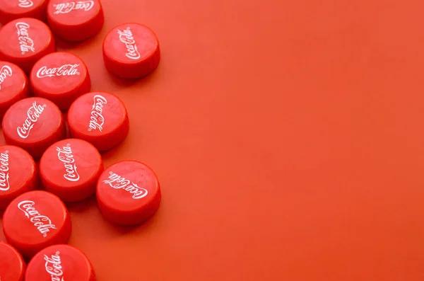 Muchas tapas rojas con logo de cola de coca sobre fondo rojo —  Fotos de Stock