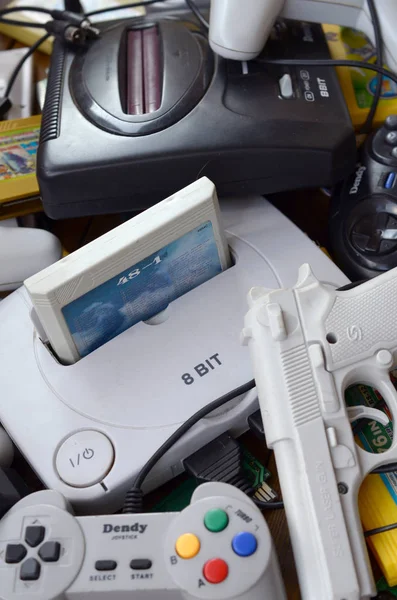 Pile of old 8-bit video game consoles and many gaming accessories like a joysticks and cartridges — Stock Photo, Image