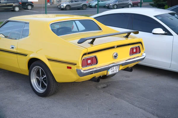 Visão traseira de Ford Mustang Mach 1 na cor amarela brilhante no lugar de estacionamento público — Fotografia de Stock