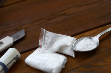 Ahşap zemin üzerinde beyaz toz dolu çakmak ve kaşık. Eroin bağımlılığı konsepti