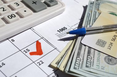 1065 Ortaklık Geliri Dolarlar, hesap makinesi ve kalemle 15 Nisan tarihli takvim sayfasında boş olarak geri döndü