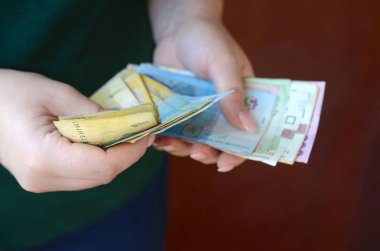 Ukrayna 'da kadın eli, maaş döneminde büyük miktarda Ukrayna parası sayıyor.