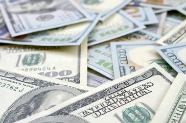 Arka planda 100 dolarlık banknotların üst görüntüsü var. Kullanıcı para birimi kavramı ve zengin yaşam