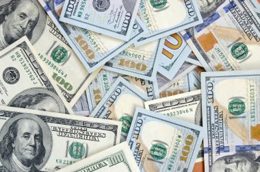 Arka planda 100 dolarlık banknotların üst görüntüsü var. Kullanıcı para birimi kavramı ve zengin yaşam