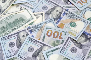 Arka planda 100 dolarlık banknotların üst görüntüsü var. Kullanıcı para birimi kavramı ve zengin yaşam