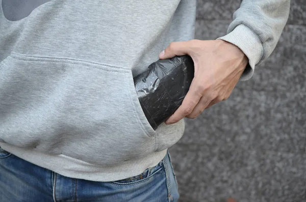 Traficante de drogas levando saco com cocaína fora do bolso com capuz em telhas escuras fundo close up — Fotografia de Stock