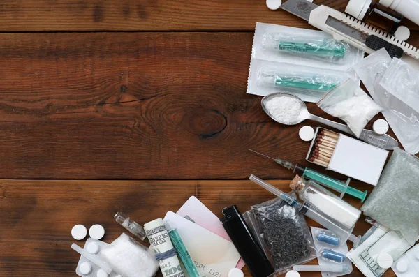 A lot of narcotic substances and devices for the preparation of drugs lie on an old wooden table — Stock Photo, Image