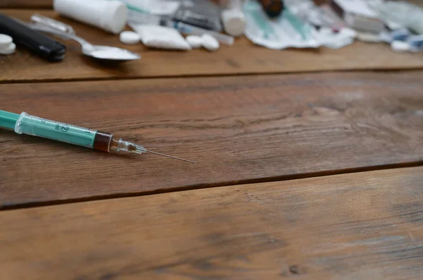 Una gran cantidad de sustancias narcóticas y dispositivos para la preparación de drogas se encuentran en una vieja mesa de madera —  Fotos de Stock