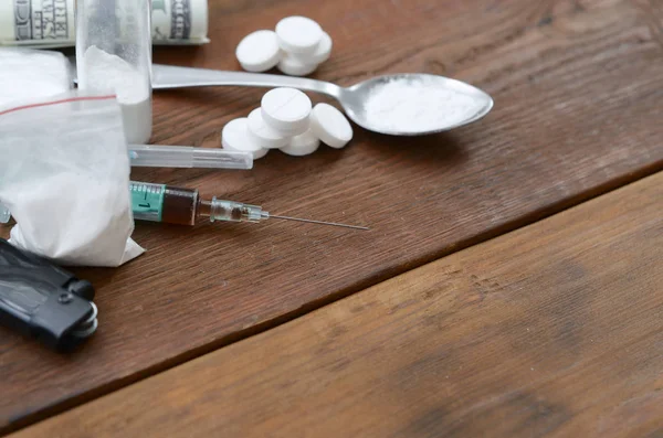 Sok narkotikus anyag és kábítószer-előállító eszköz fekszik egy régi fából készült asztalon. — Stock Fotó