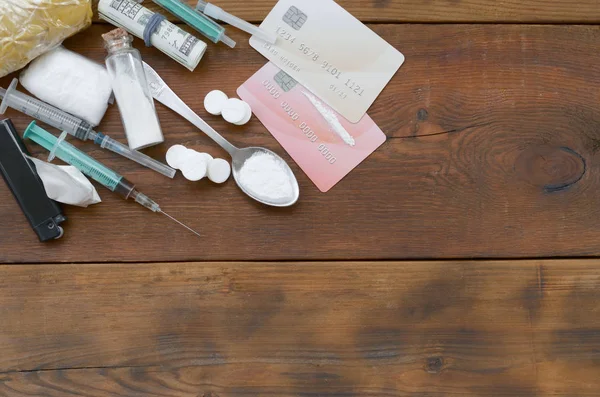 Beaucoup de substances narcotiques pilules et dispositifs pour la préparation de drogues reposent sur une vieille table en bois — Photo