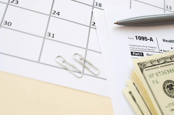 Irs Form 1095-A Health Insurance Marketplace Výpis daně prázdný leží s perem a mnoha stodolarových bankovek na stránce kalendáře — Stock fotografie