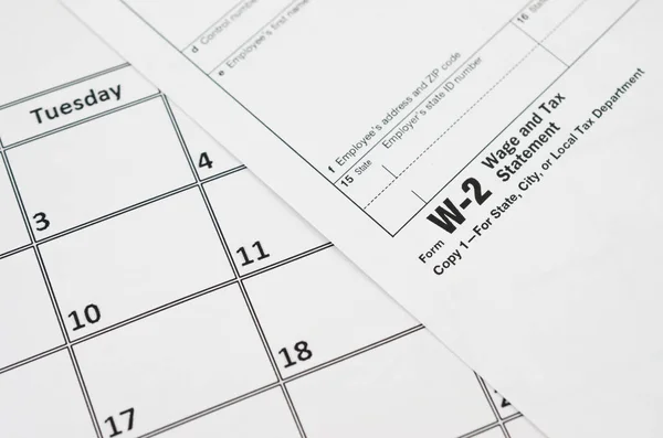 W-2 Lohn- und Steuererklärung leer liegt auf leerem Kalenderblatt — Stockfoto