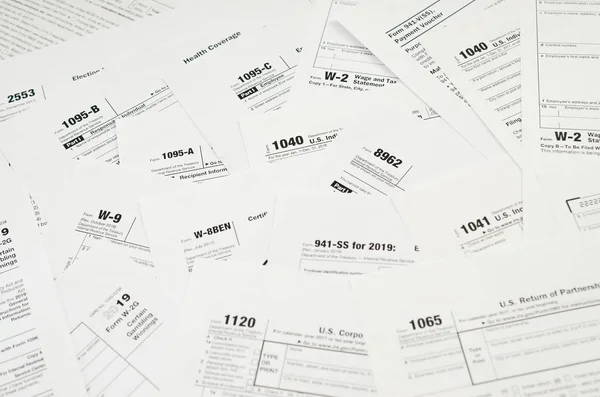 Muitos espaços em branco formulário de imposto encontra-se na mesa de perto. Colaboradores fiscais papelada rotina e conceito de burocracia — Fotografia de Stock