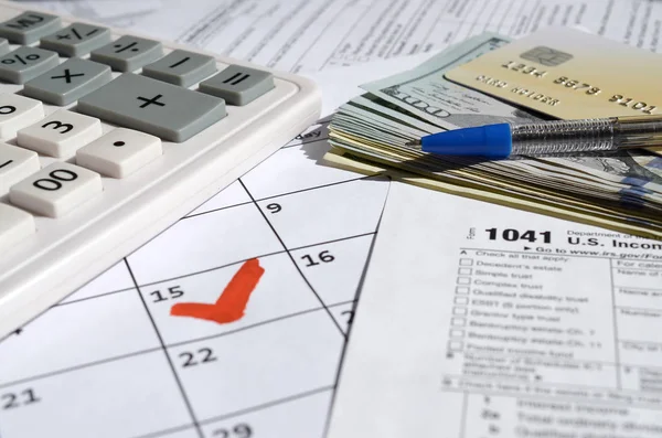 1041 Income Tax Return for Estates and Trusts blank with dollar bills, calculator and pen on calendar page with marked 15th April — Stock Photo, Image