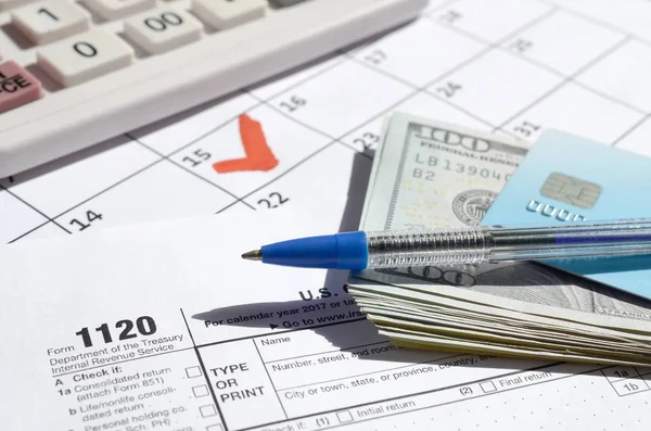 1120 Corporation Income Tax Return blank with dollar bills, calculator and pen on calendar page with marked 15th April — Stock Photo, Image