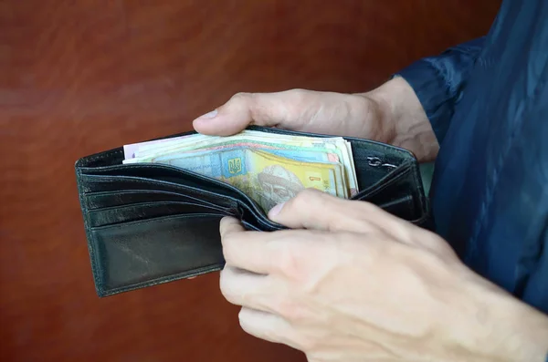 Närbild manliga händer öppnade plånbok eller handväska med ukrainska pengar valuta hryvnia — Stockfoto