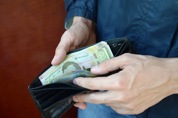 Close up mani maschili aperto il portafoglio o borsa con moneta ucraina grivna — Foto Stock