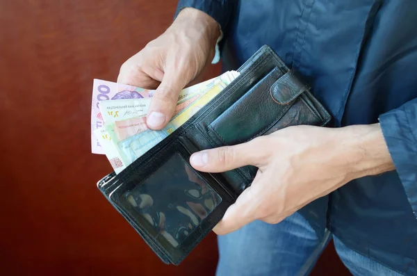 Fermer les mains masculines ouvert le portefeuille ou sac à main avec de l'argent ukrainien monnaie hryvnia — Photo