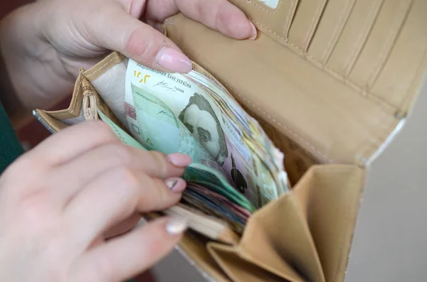 Mani femminili in possesso di bollette grivna ucraina in piccolo sacchetto di denaro o portafoglio — Foto Stock