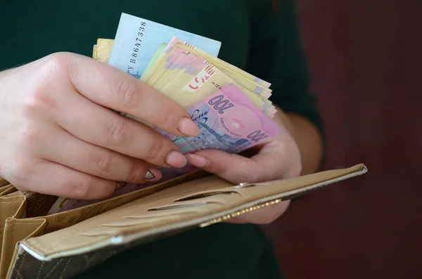 Mani femminili in possesso di bollette grivna ucraina in piccolo sacchetto di denaro o portafoglio — Foto Stock