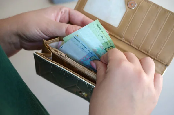 Dłonie kobiet trzymających ukraińskie banknoty hrywien w małej sakwie lub portfelu — Zdjęcie stockowe