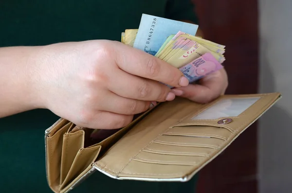 Női kéz kezében ukrán hrivnya számlák kis pénzeszsák vagy pénztárca — Stock Fotó