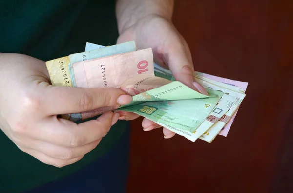 女性の手はウクライナでの給与期間中にウクライナのお金の大きな量をカウント — ストック写真