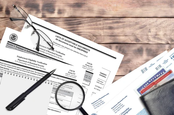 USCIS form I-9 Employment eligibility verification lies on flat lay office table and ready to fill. U.S. Citizenship and Immigration services paperwork concept. Top view