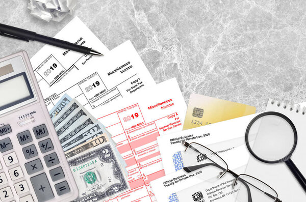 IRS form 1099-MISC Miscellaneous income lies on flat lay office table and ready to fill. U.S. Internal revenue services paperwork concept. Time to pay taxes in United States. Top view