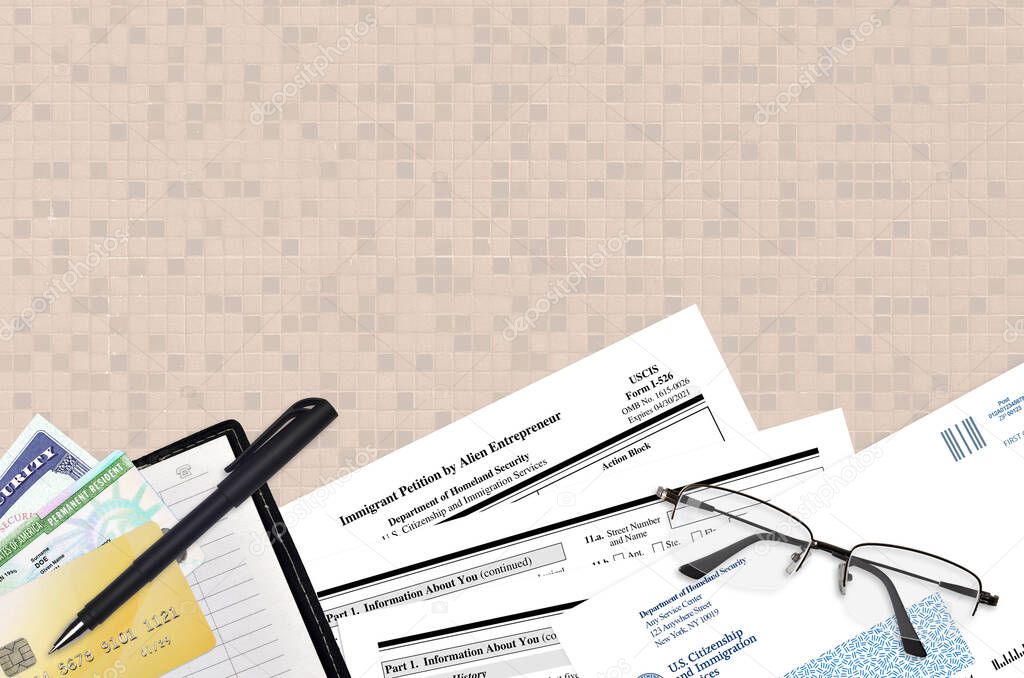 USCIS form I-586 Immigrant petition by Alien Entrepreneur lies on flat lay office table and ready to fill. U.S. Citizenship and Immigration services paperwork concept. Top view