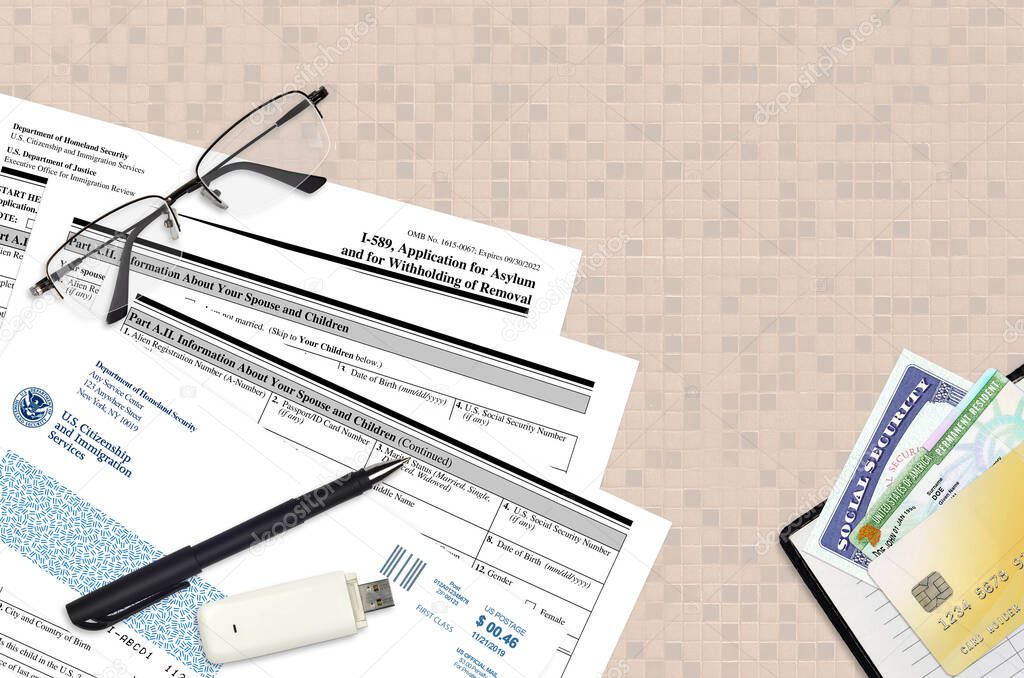 USCIS form I-589 Application of asylum and for withholding of removal lies on flat lay office table and ready to fill. U.S. Citizenship and Immigration services paperwork concept. Top view