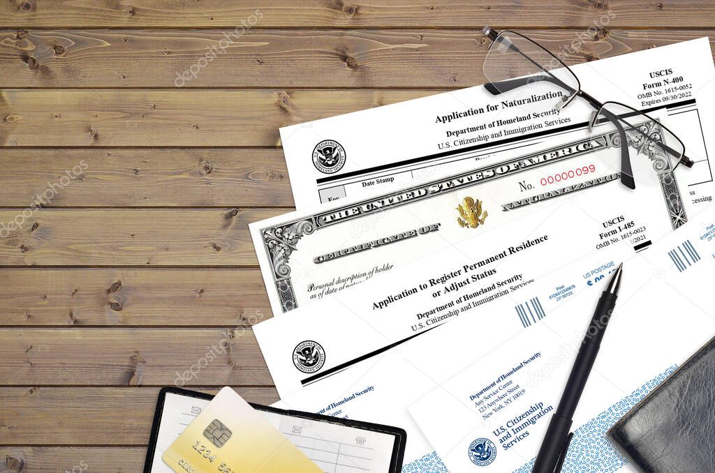 USCIS form I-485 Application to register permanent residence or adjust status and N-400 Application for naturalization with Certificate of naturalization lies on office table and ready to fill.