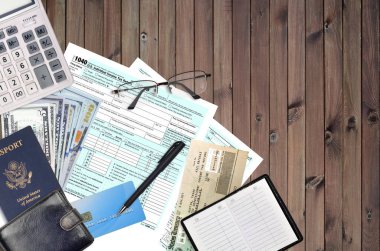 IRS form 1040 U.S. Individual income tax return with refund check lies on flat lay office table and ready to fill. U.S. Internal revenue services paperwork concept. Time to pay taxes in United States clipart
