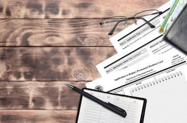 Kalıcı oturma kartını değiştirmek için USCIS form I-90 uygulaması düz bir ofis masasında duruyor ve doldurmaya hazır. ABD Vatandaşlık ve Göçmenlik Bürosu evrakları konsepti. Üst görünüm