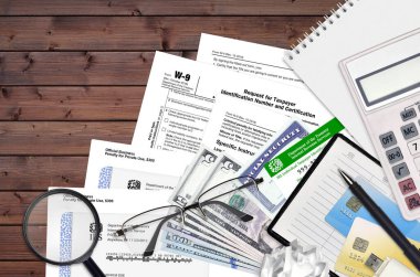 Vergi dairesi formu W-9 vergi mükelleflerinin kimlik numarası ve sertifikası için başvuru formu düz masa üzerinde ve doldurmaya hazır. ABD Gelir Hizmetleri evrak konsepti. Vergi ödeme zamanı.