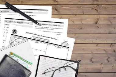 Kalıcı oturma kartını değiştirmek için USCIS form I-90 uygulaması düz bir ofis masasında duruyor ve doldurmaya hazır. ABD Vatandaşlık ve Göçmenlik Bürosu evrakları konsepti. Üst görünüm