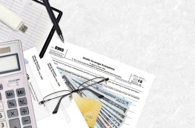 Vergi dairesi formu 8965 Sağlık Muafiyetleri düz bir ofis masasında ve doldurmaya hazır. ABD Gelir Hizmetleri evrak konsepti. Birleşik Devletler 'de vergi ödeme zamanı. Üst görünüm