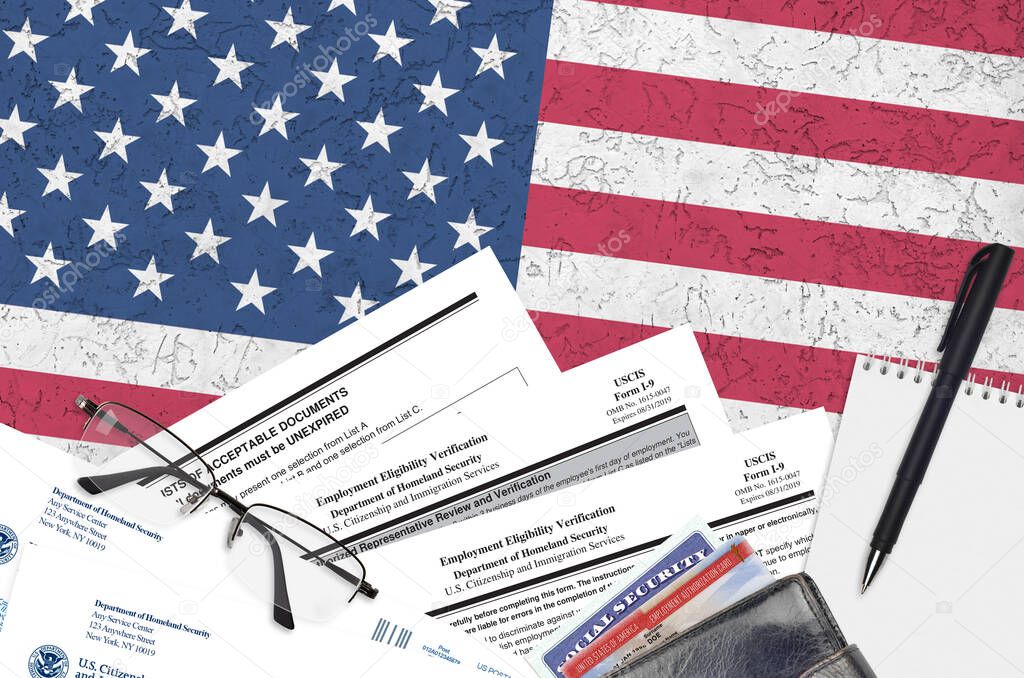 USCIS form I-9 Employment eligibility verification lies on flat lay office table and ready to fill. U.S. Citizenship and Immigration services paperwork concept. Top view